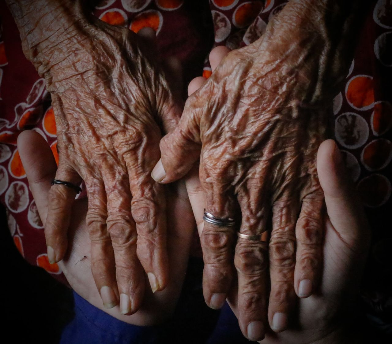 A close-up image of elderly hands held by younger hands, showcasing age and care.